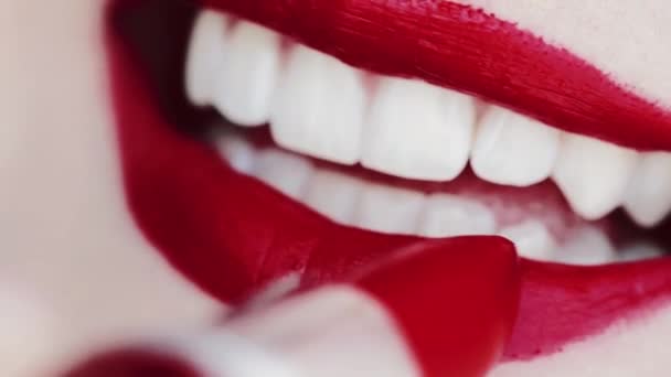 Wargi z czerwoną szminką i białymi zębami uśmiechnięte, makro zbliżenie szczęśliwy uśmiech kobiety, zdrowie zębów i makijaż urody — Wideo stockowe