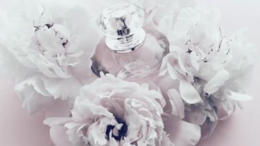Şakayık çiçekli beyaz parfüm şişesi lüks kozmetik, moda ve güzellik ürünleri arka planında şık bir koku.
