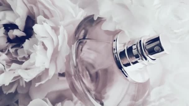 Biała butelka perfum z kwiatami piwonii, elegancki zapach jako luksusowy kosmetyk, moda i piękno tło produktu — Wideo stockowe