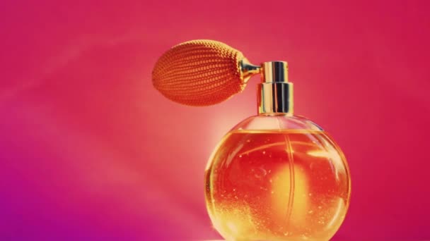 Goldene Duftflasche und leuchtende Lichterketten auf rosa Hintergrund, glamouröser Parfümduft als Urlaubsparfümerieprodukt für Kosmetik- und Schönheitsmarken — Stockvideo