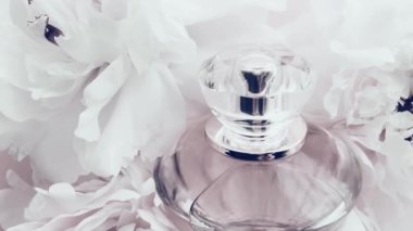 Şakayık çiçekli beyaz parfüm şişesi lüks kozmetik, moda ve güzellik ürünleri arka planında şık bir koku.