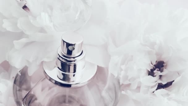 Şakayık çiçekli beyaz parfüm şişesi lüks kozmetik, moda ve güzellik ürünleri arka planında şık bir koku. — Stok video