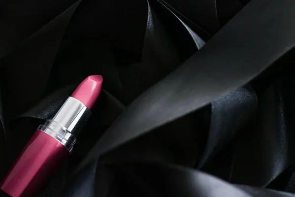 Lápiz labial rosa sobre fondo de seda negro, maquillaje de lujo y cosméticos de belleza — Foto de Stock