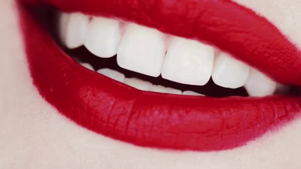 Labios con lápiz labial rojo y dientes blancos sonriendo, macro primer plano de sonrisa femenina feliz, salud dental y maquillaje de belleza — Vídeos de Stock