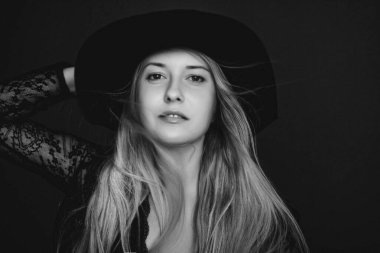 Şapka takan güzel sarışın kadın moda kampanyası ve güzellik markası için siyah beyaz bir sanat filmi portresi.