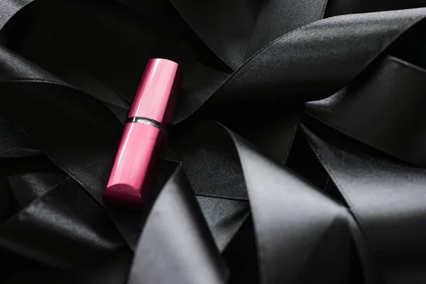 Lápiz labial rosa sobre fondo de seda negro, maquillaje de lujo y cosméticos de belleza — Foto de Stock