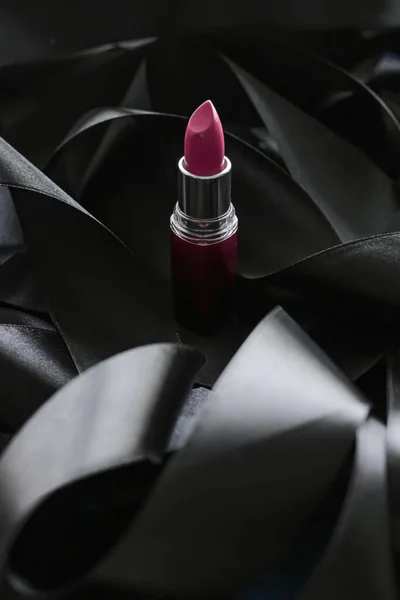 Batom rosa sobre fundo de seda preta, maquiagem de luxo e beleza cosmética — Fotografia de Stock