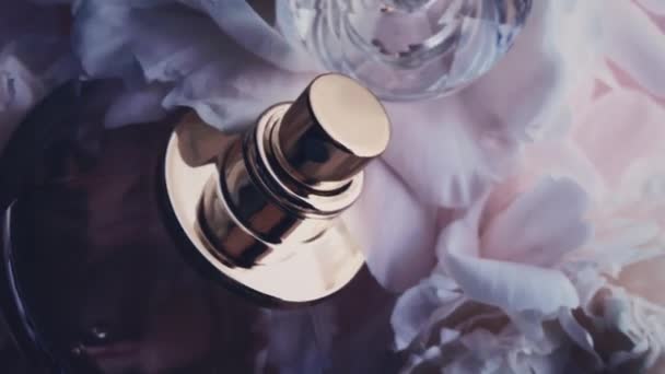 Fioletowa butelka perfum z kwiatami piwonii, elegancki zapach jako luksusowy kosmetyk, moda i piękno tło produktu — Wideo stockowe