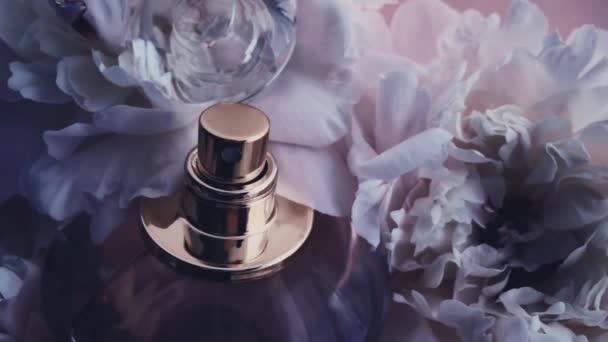 Frasco de perfume púrpura con flores de peonía, aroma de fragancia elegante como cosmético de lujo, fondo de productos de moda y belleza — Vídeo de stock