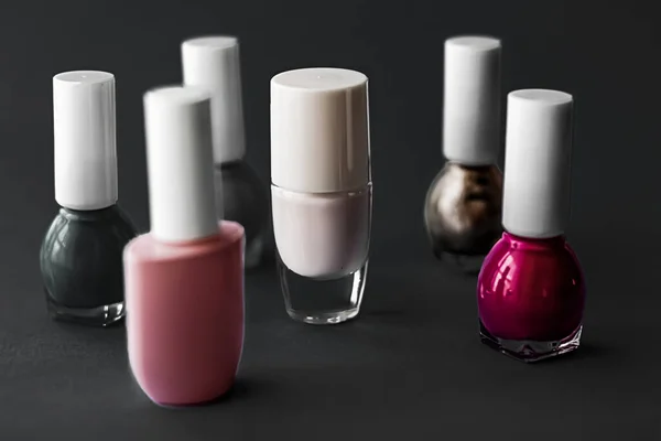 Nail polish bottles on black background, beauty brand