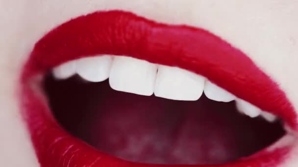 Губи з червоною помадою і білі зуби посміхаються, макро крупним планом щасливої жіночої посмішки, здоров'я зубів і макіяж краси — стокове відео