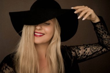 Şapka takan zarif sarışın kadın moda kampanyası ve güzellik markası için sanatsal film portresi.