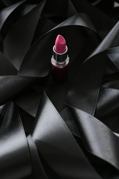 Lápiz labial rosa sobre fondo de seda negro, maquillaje de lujo y cosméticos de belleza — Foto de Stock