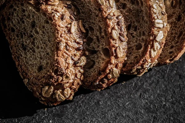 新鮮な全粒穀物種子パン、有機小麦の粉、食品ブログや料理本のレシピの背景としてクローズアップスライステクスチャ — ストック写真