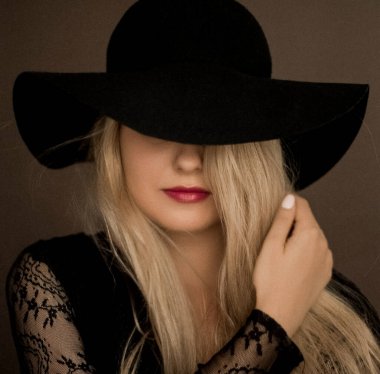 Şapka takan zarif sarışın kadın moda kampanyası ve güzellik markası için sanatsal film portresi.