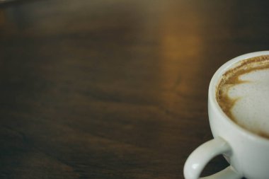Kafede ahşap masada kahve bardağı ve kahve çekirdekleri