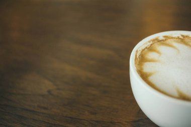 Kafede ahşap masada kahve bardağı ve kahve çekirdekleri