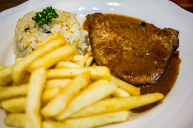 ahşap masada beyaz plaka ile biftek 