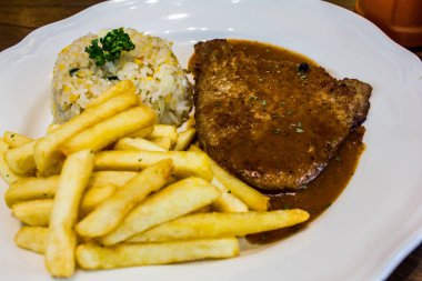 ahşap masada beyaz plaka ile biftek 