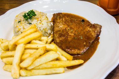 ahşap masada beyaz plaka ile biftek 