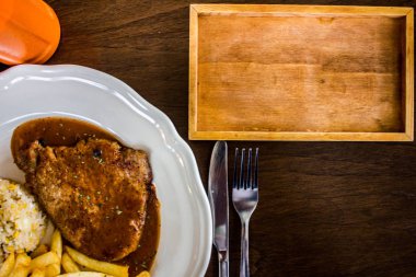 ahşap masada beyaz plaka ile biftek 