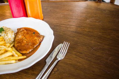 ahşap masada beyaz plaka ile biftek 