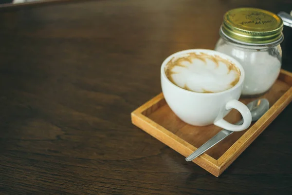 Coffee cup and coffee beans on wooden table  in cafe