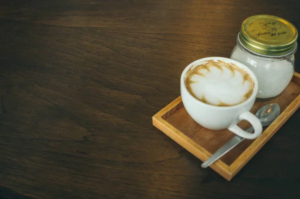 咖啡杯和咖啡豆在咖啡厅的木桌上 — 图库照片