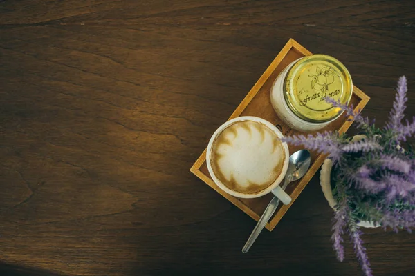 Taza de café y granos de café en la mesa de madera en la cafetería — Foto de Stock