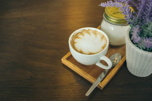 Taza de café y granos de café en la mesa de madera en la cafetería — Foto de Stock