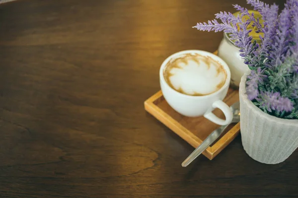 Taza de café y granos de café en la mesa de madera en la cafetería — Foto de Stock