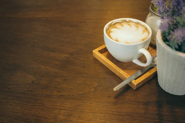 Taza de café y granos de café en la mesa de madera en la cafetería — Foto de Stock