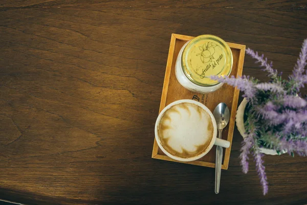 Taza de café y granos de café en la mesa de madera en la cafetería — Foto de Stock