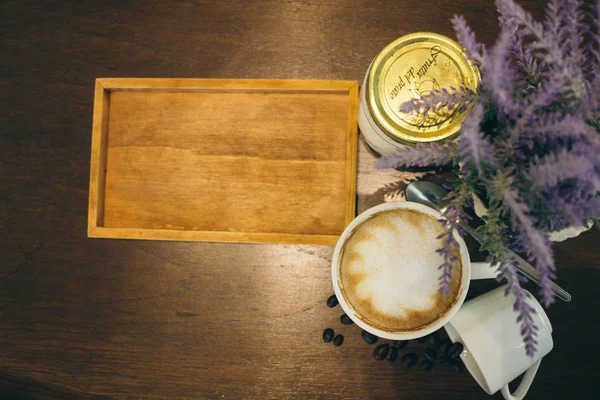 Taza de café y granos de café en la mesa de madera en la cafetería — Foto de Stock