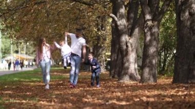 Mutlu bir aile olan park lane bir sonbahar gününde yürüyüş. 4 k yavaş hareket.