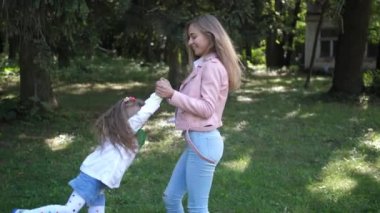 Genç Anne ile çocuk sonbahar parkta fırtınası. Mutlu oyun ve kızı ile gülmek. Ağır çekim. 4k
