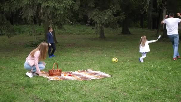 Feliz familia padre, madre, hijo e hija se juegan en el parque de otoño. En cámara lenta. 4k — Vídeos de Stock