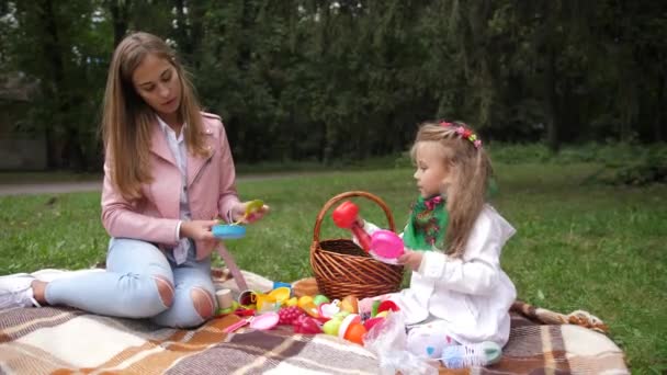 Mor och hennes dotter lilla flicka som leker i en höst park. Plastleksaker. 4 k. slowmotion. — Stockvideo