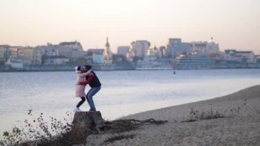 Sonbahar. Mutlu ouple AVING eğlenceli açık havada. Çocuk kız arkadaşı kollarında yükseltir. Özgürlük kavramı. Sonbahar beach 4k yavaş Mo