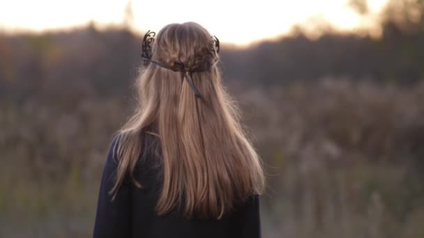 Primer plano, una chica con una hermosa máscara hace un beso a la cámara. Todo sucede en el otoño en el campo contra el atardecer 4K Slow Mo — Vídeos de Stock