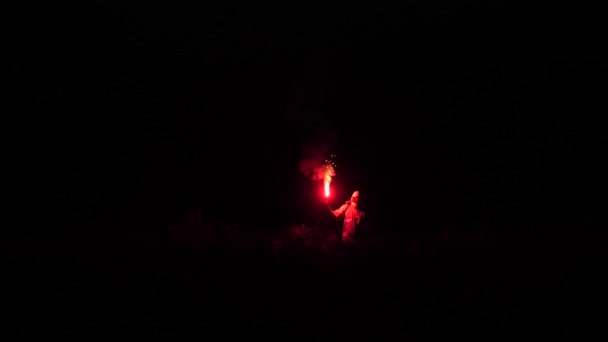 Astronaut with red fire in his hand walks in an unknown space. In the dark astronauts silhouette is visible 4K Slow Mo — Stock Video