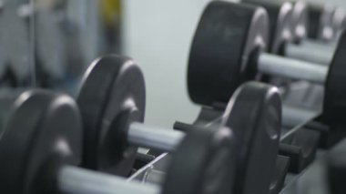 Yakın çekim. Erkek el koymak dumbbells raf 4k yavaş Mo