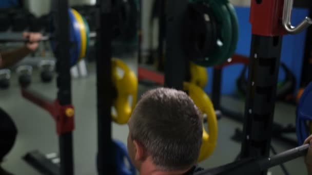 View from the back. Man crouches with a barbell 4K Slow Mo — Stock Video
