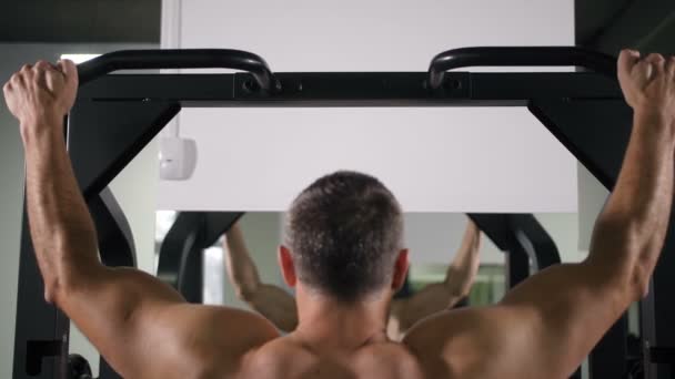 Un hombre con una espalda muscular se detiene en un simulador 4K Slow Mo — Vídeos de Stock