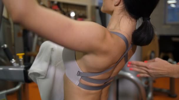 Close-up of the back muscles. Beautiful girl is engaged on the simulator 4K Slow Mo — Stock Video