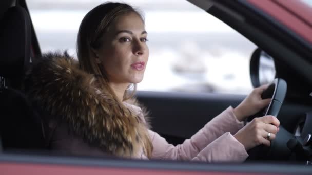 La chica conduce el coche, se detiene en la intersección, mira a la carretera va más lejos 4K Slow Mo — Vídeo de stock