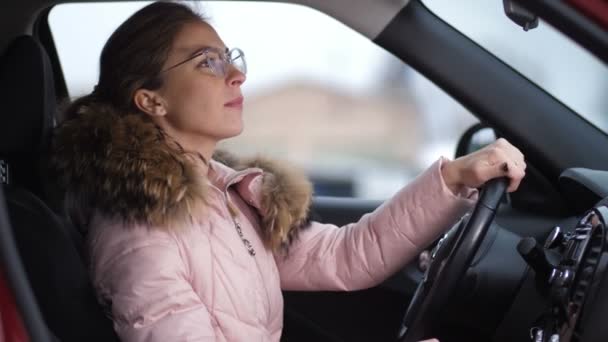 Portret dziewczyny w okularach, który jest jazda samochodem, ona powoduje wyłączenie samochodu i wychodzi 4k Slow Mo — Wideo stockowe