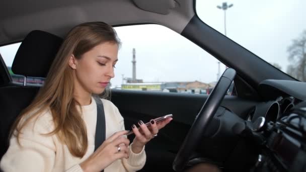 Genç bir kız telefonda bir iletiyi okur, arabada. Çok üzgün 4 k kız yavaş Mo — Stok video