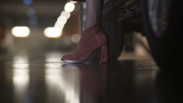 Gros plan, belles jambes féminines sortent de la voiture. Des talons. Parking 4K Lent Mo — Video