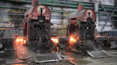 Metalurji. Ateş çelik aparatı ile taşır. Genel planı.